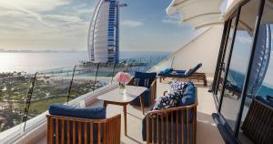 a balcony with chairs and a table on a cruise ship at Jumeirah Beach Hotel Dubai in Dubai