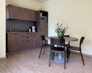 ein Esszimmer mit einem Tisch und Stühlen sowie eine Küche in der Unterkunft Residence Alesi in Malcesine