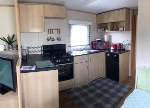 a small kitchen with a stove and a sink at Hill View in Ballantrae