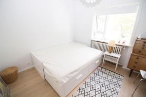 ein Schlafzimmer mit einem großen weißen Bett und einem Fenster in der Unterkunft Sunny Reykjavik Family Apartment in Reykjavík