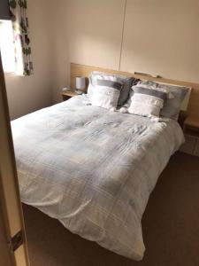 a bedroom with a bed with white sheets and pillows at Hill View in Ballantrae