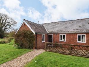 a red brick house with a wooden fence at The Old Dairy in Bridport +13 photos