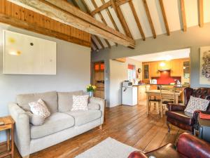 a living room with a couch and a kitchen at The Old Dairy in Bridport