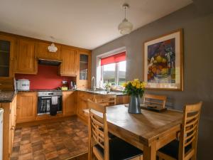 a kitchen with a wooden table with a vase of flowers on it at The Old Dairy in Bridport
