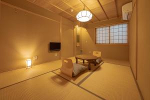uma sala de estar com uma mesa e uma cadeira em Saju Kyoto 茶住 京都 em Quioto
