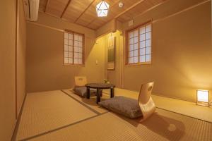 Saju Kyoto 茶住 京都 في كيوتو: غرفة مع طاولة وكراسي في غرفة