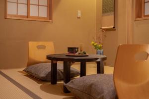 uma mesa num quarto com duas cadeiras e uma mesa com uma mesa em Saju Kyoto 茶住 京都 em Quioto