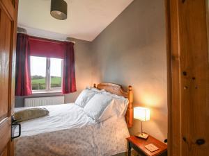 a small bedroom with a bed and a window at The Old Dairy in Bridport