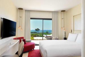 a hotel room with a bed and a tv at Hilton Taghazout Bay Beach Resort & Spa in Taghazout