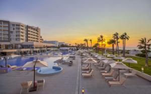 莫納斯提爾的住宿－Hilton Skanes Monastir Beach Resort，海滩旁的一组躺椅和遮阳伞