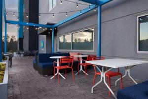 a patio with tables and chairs in a building at Tru By Hilton North Augusta in North Augusta