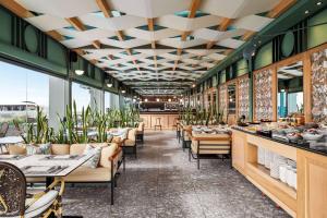 a restaurant with tables and chairs and windows at Zeus Essence Athens Central, former Athens Key in Athens