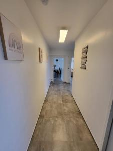an empty hallway with white walls and wood floors at Chic Appart im Herzen Bad Nauheim, 2-ZW, 65qm in Bad Nauheim