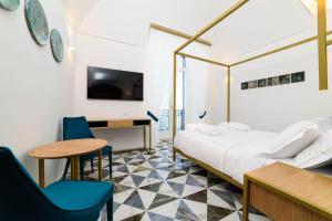 pokój hotelowy z łóżkiem, stołem i krzesłami w obiekcie Palazzo Vitagliano w Amalfi