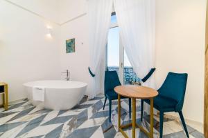 łazienka z wanną, 2 krzesłami i stołem w obiekcie Palazzo Vitagliano w Amalfi +35 zdjęć