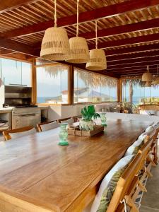 un comedor con una gran mesa de madera y sillas en Punta Veleros, Los Órganos casa de playa, en Talara