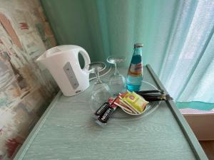 a glass table with a bottle of alcohol and glasses at Rathaushotel in Eibenstock