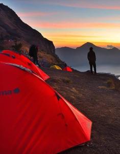 a group of people standing on top of a mountain at RINJANI EXPEDITION BASECAMP in Masbagik