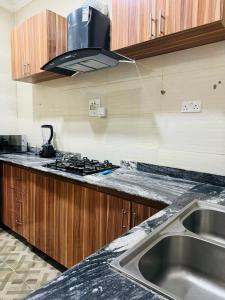 a kitchen with a sink and a stove at Icon Grand Apartments (The Rock View) in Abuja