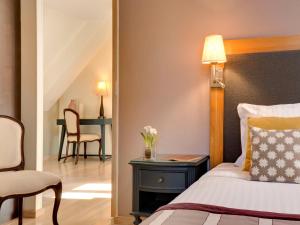 sypialnia z łóżkiem i stołem z krzesłem w obiekcie Hotel Castel Maintenon w mieście Maintenon