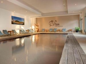 ein Swimmingpool in einem Hotel mit Stühlen und Schild in der Unterkunft Castel Maintenon Handwritten Collection in Maintenon