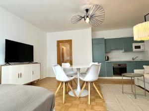 eine Küche mit einem Tisch und weißen Stühlen im Zimmer in der Unterkunft Chic Apartment - Quiet Area - Next to Hospital in Wien