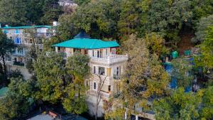 an aerial view of a mansion with a blue roof at SaffronStays Naiintara in Nainital