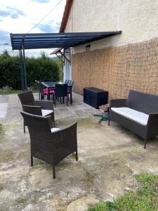 eine Terrasse mit Stühlen, einem Sofa und einem Tisch in der Unterkunft Le Refuge de l'Ours in Baerenthal