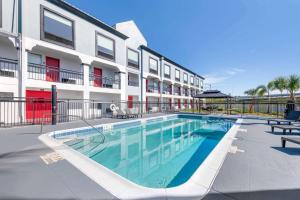 a swimming pool in front of a apartment building at Super 8 by Wyndham Orlando Near Florida Mall in Orlando