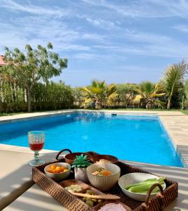 una bandeja de comida en una mesa junto a la piscina en Punta Veleros, Los Órganos casa de playa, en Talara