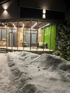 ein Gebäude mit einem Stapel Schnee davor in der Unterkunft Vilgrand in Vatra