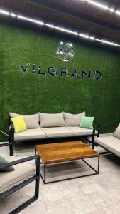a room with couches and a green wall with a sign at Vilgrand in Vatra