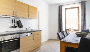 a kitchen with wooden cabinets and a table with a dining room at Fewo Nahe - Hostel für Erwachsene in Bad Sobernheim