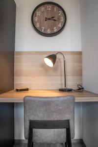 un escritorio con una lámpara y un reloj en la pared en Fewo Nahe, en Bad Sobernheim