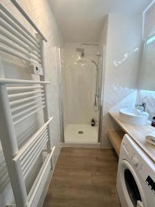 une salle de bain avec douche et lavabo et une machine à laver dans l'établissement Le City-Break - T3 en centre-ville avec un parking sécurisé, à Vannes 13 autres photos