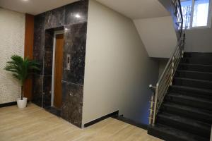 a stairwell with a black marble wall at Miot Grande in Chennai