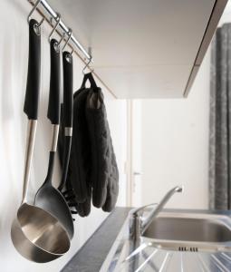 uma cozinha com utensílios pendurados numa prateleira ao lado de um lavatório em Fewo Nahe em Bad Sobernheim