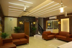 a waiting room with two chairs and a ceiling at Miot Grande in Chennai