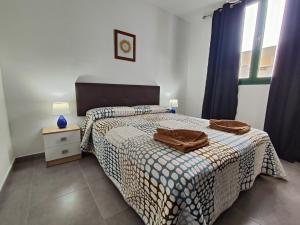a bedroom with a bed with a brown bag on it at RealRent Costa Teguise Beach in Costa Teguise +259 photos