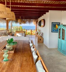 a living room with a bed and a table and chairs at Punta Veleros, Los Órganos casa de playa in Talara