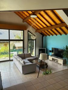 een woonkamer met een bank en een tv bij Grande maison Proche Albertville in La Bâthie
