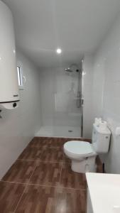 ein weißes Bad mit einem WC und einer Dusche in der Unterkunft Casa Lizz in Lumpiaque
