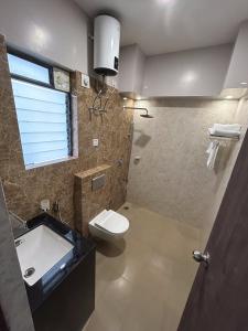 uma casa de banho com um WC e um lavatório em The Pearl Club Resort em Santiniketan