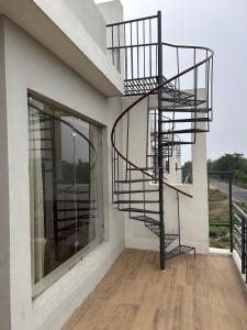 uma escada em espiral na lateral de um edifício em The Pearl Club Resort em Santiniketan