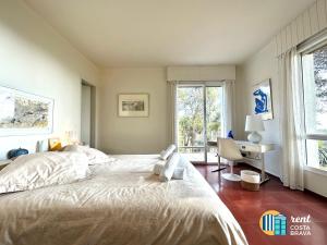 1 dormitorio con cama, escritorio y ventana en Casa Vista Mar, Platja d´Aro, en Platja d'Aro