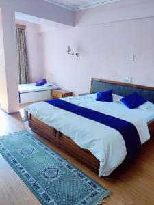1 dormitorio con 1 cama grande con almohadas azules en Hotel Shiva's Regency, en Bikaner