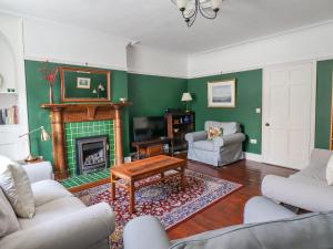 a living room with green walls and a fireplace at Victoria House in Alnwick