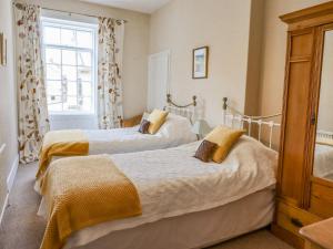 a bedroom with two beds and a window at Victoria House in Alnwick