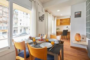 uma sala de jantar com uma mesa e cadeiras e uma janela em BBarcelona Gràcia Nova Flat em Barcelona