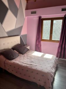 een slaapkamer met een groot bed in een roze kamer bij Grande maison Proche Albertville in La Bâthie